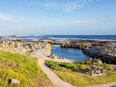 a picnic table and a bench on the beach at Two Palm House - Vermont Hermanus in Hermanus
