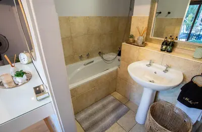 a bathroom with a sink and a bath tub and a sink at Century City Luxury 2 bedroom apartment in Cape Town in Cape Town
