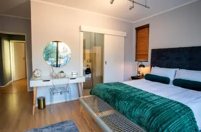 a bedroom with a large bed and a mirror at Century City Luxury 2 bedroom apartment in Cape Town in Cape Town