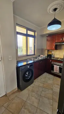 a kitchen with a washing machine in the middle at La Palmera - Island Club Canal Front in Cape Town