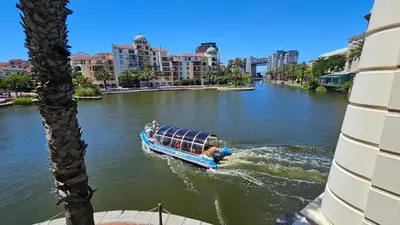 a boat on a river with buildings in the background at La Palmera - Island Club Canal Front in Cape Town