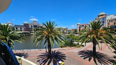 a city with palm trees and a river and buildings at La Palmera - Island Club Canal Front in Cape Town