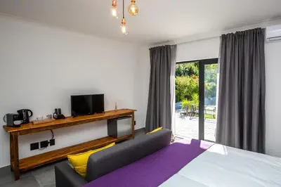 a bedroom with a bed and a couch and a tv at Casa iLanga guesthouse in Somerset West