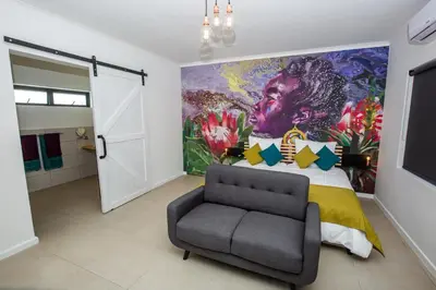 a bedroom with a large painting on the wall at Casa iLanga guesthouse in Somerset West