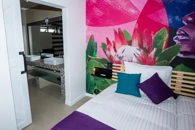 a bedroom with a bed with a painting on the wall at Casa iLanga guesthouse in Somerset West
