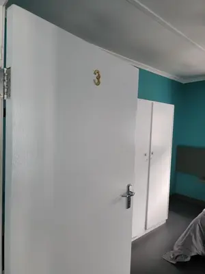 a room with a white door and a blue wall at Hasate Guest House ,4 st james street Oakdale Belliville Cape Town South Africa in Cape Town