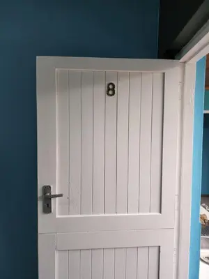 a white door in a room with a blue wall at Hasate Guest House ,4 st james street Oakdale Belliville Cape Town South Africa in Cape Town