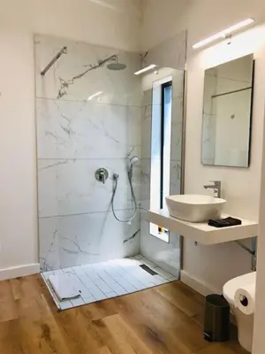 a white bathroom with a sink and a shower at Glow Boutique Suites & Guesthouse in Hermanus