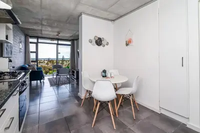 a kitchen and dining room with a table and chairs at 2 Bedroom Secure Pool Strong WiFi in Cape Town