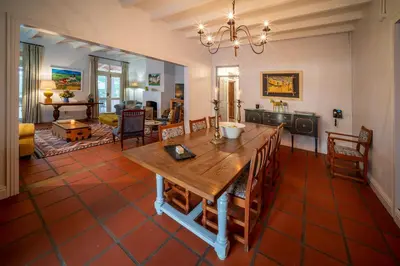 a dining room and living room with a table and chairs at Wild Olive House at Bartholomeus Klip in Hermon