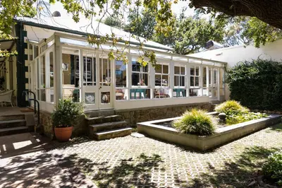a house with a conservatory with a garden at Wild Olive House at Bartholomeus Klip in Hermon