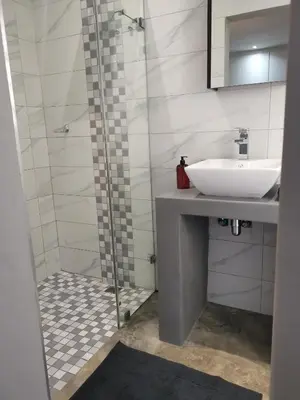 a bathroom with a sink and a shower at Gray Cottage in Strand