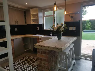 a kitchen with a counter with a vase of flowers on it at Gray Cottage in Strand