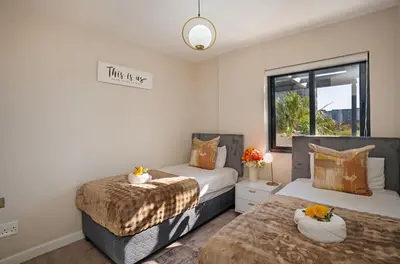 a bedroom with two beds and a sign that says think of us at Knightsbridge Terrace in Cape Town