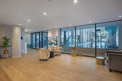 a large room with chairs and tables and windows at Knightsbridge Terrace in Cape Town