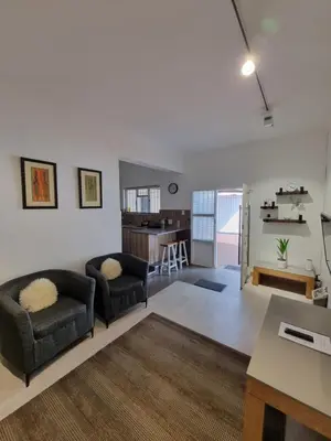 a living room with two chairs and a table at The Ridge in Cape Town