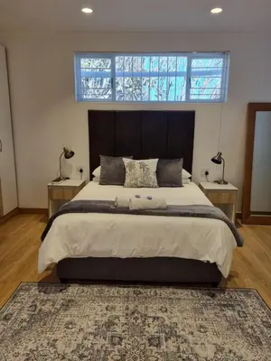 a bedroom with a large bed with two night stands at The Ridge in Cape Town