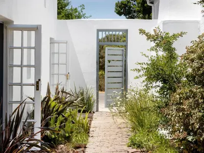 a door to a white house with plants at Greyton Lodge in Greyton