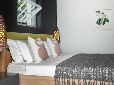 a bedroom with a bed with white sheets and pillows at Greyton Lodge in Greyton