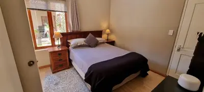 a small bedroom with a bed and a window at Tranquility Studio in Somerset West
