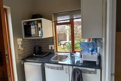 a small kitchen with a sink and a microwave at Tranquility Studio in Somerset West