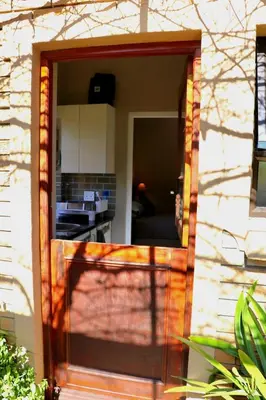 a sliding glass door into a kitchen in a house at Tranquility Studio in Somerset West