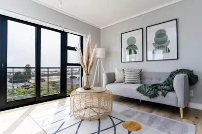 a living room with a couch and a table at Burmeister403 - Modern 1 Bedroom Apartment across from Ocean in Cape Town