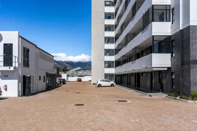 a car parked in a parking lot in front of a building at Burmeister403 - Modern 1 Bedroom Apartment across from Ocean in Cape Town