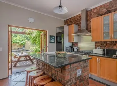 a kitchen with a counter with stools in it at Tuscany Hauss Villa in Somerset West