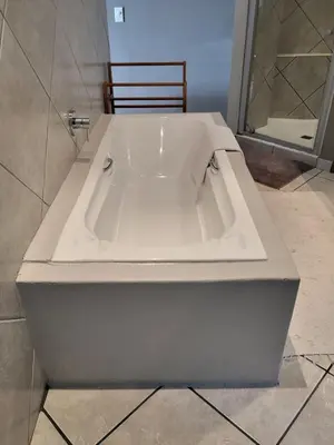 a large white bath tub in a bathroom at Perle Du Cap in Paarl