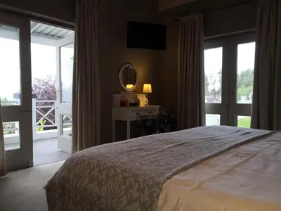 a bedroom with a bed and a desk with a mirror at Perle Du Cap in Paarl