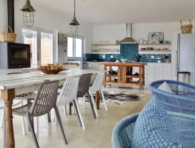 a kitchen with a table and chairs in a kitchen at Seafront house with a view in Kleinmond