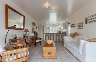 a living room with a white couch and a table at 30 Nagua Bay in Cape Town