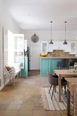 a kitchen with blue cabinets and a table with chairs at La Belle Vie in Franschhoek