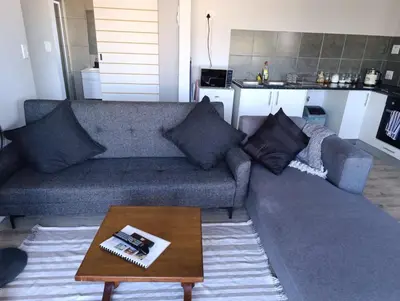 a living room with a couch and a coffee table at Lovely 2 bedroom condo with balcony and a view! in Cape Town