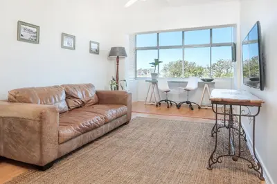 a living room with a brown couch and a table at Oak on Main in Hermanus
