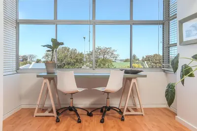 a room with a table and two chairs in front of a window at Oak on Main in Hermanus