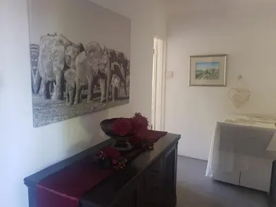 a room with a table with a picture of elephants on the wall at Relax on Blair in Cape Town