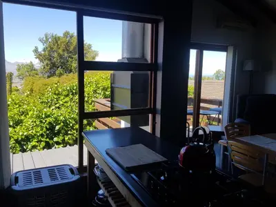 a kitchen with a stove and a view of a balcony at Relax on Blair in Cape Town