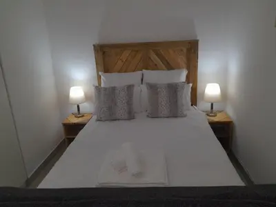 a bedroom with a bed with two lamps on both sides at Oxford Getaway-House in Cape Town