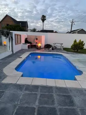 a large blue swimming pool in a yard at Perfect long stay,near Rondevlei nature reserve,wifi in Cape Town