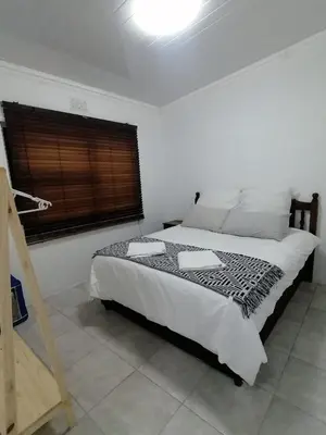 a bedroom with a large bed in a room with a window at Perfect long stay,near Rondevlei nature reserve,wifi in Cape Town