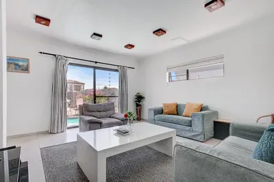 a living room with a couch and chairs and a table at Spacious Shared 3-Bedroom Villa Near Blouberg Beach Pool, Wi-Fi, Braai in Cape Town