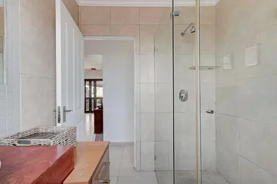 a shower with a glass door in a bathroom at Spacious Shared 3-Bedroom Villa Near Blouberg Beach Pool, Wi-Fi, Braai in Cape Town