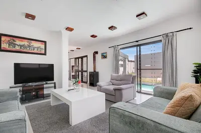 a living room with two couches and a tv at Spacious Shared 3-Bedroom Villa Near Blouberg Beach Pool, Wi-Fi, Braai in Cape Town