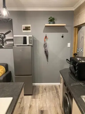a kitchen with a refrigerator and a microwave at Leafy Retreat Kenridge Trendy in Durbanville