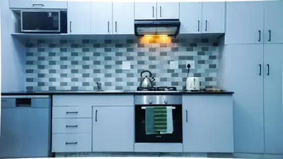 a kitchen with white cabinets and a stove top oven at 1-bedroom apartment with secure basement parking in Stellenbosch
