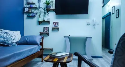 a blue living room with a couch and a table at 1-bedroom apartment with secure basement parking in Stellenbosch