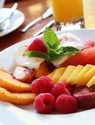 a plate of fruit and berries on a table at Pat's Place in Hermanus