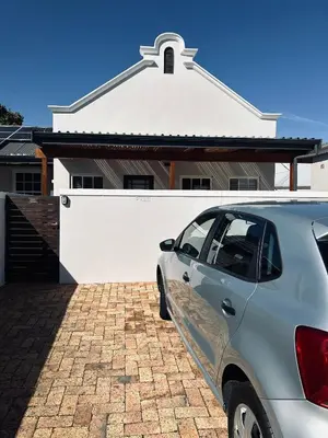 a silver car parked in front of a white garage at Botany House, in the heart of Hermanus in Hermanus